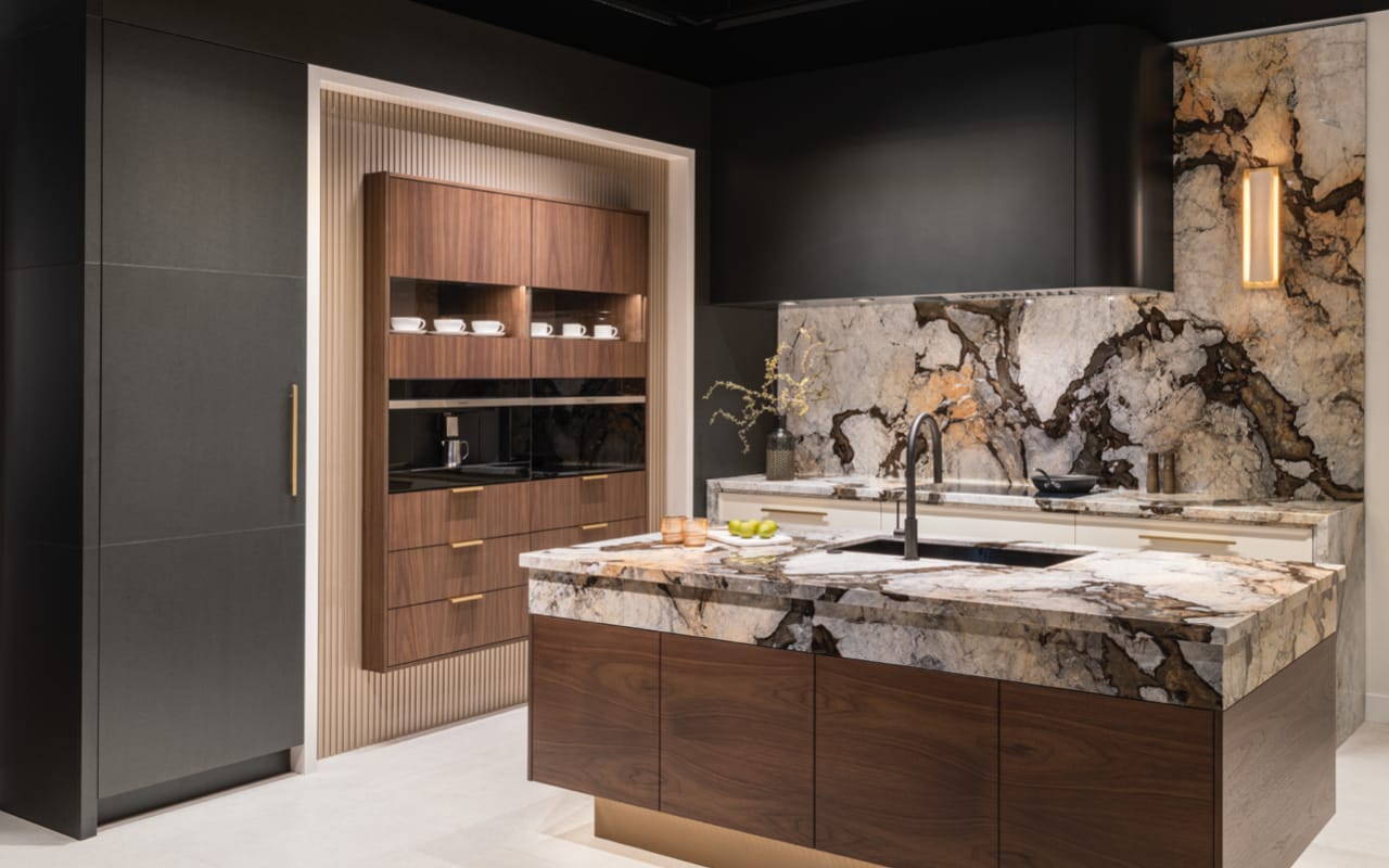 A kitchen featuring a large island. The island has wood grain cabinets, white quartz countertops, a dishwasher and two sinks.